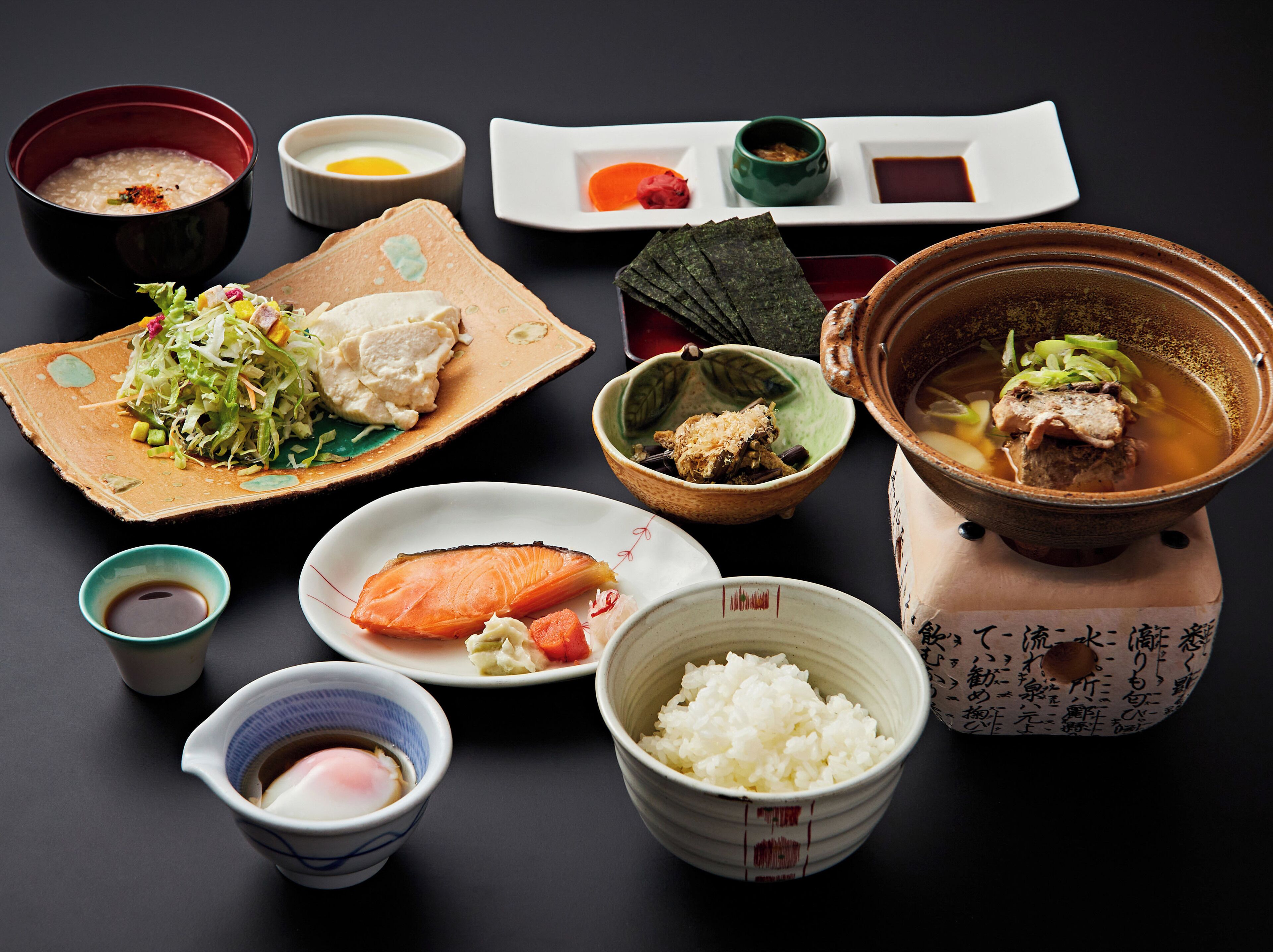 A variety of Japanese dishes including a bowl of soup, a plate with rice, and a bowl with a fish.