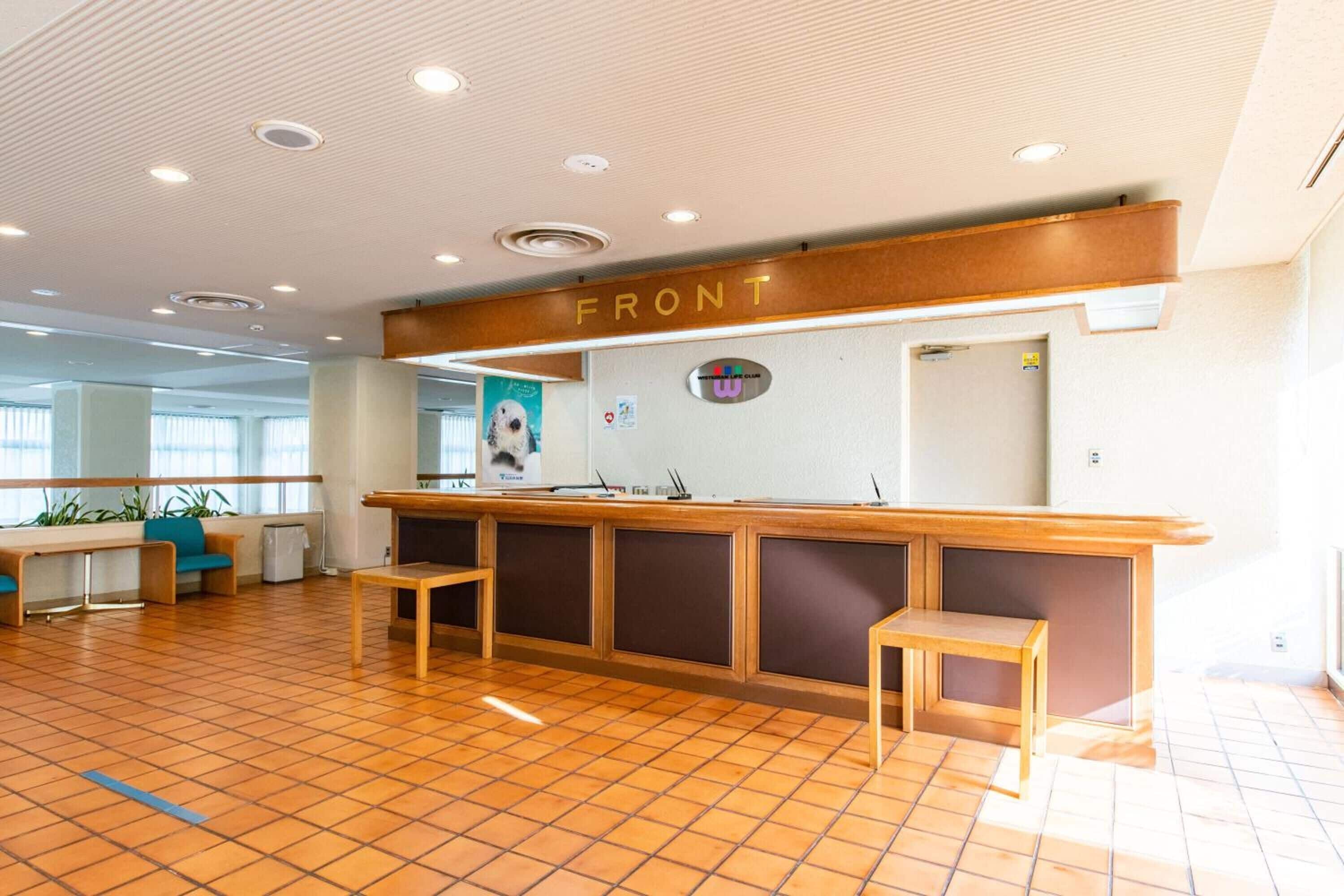 A reception area with a wooden counter, a sign labeled "FRONT", and a poster of a dog.