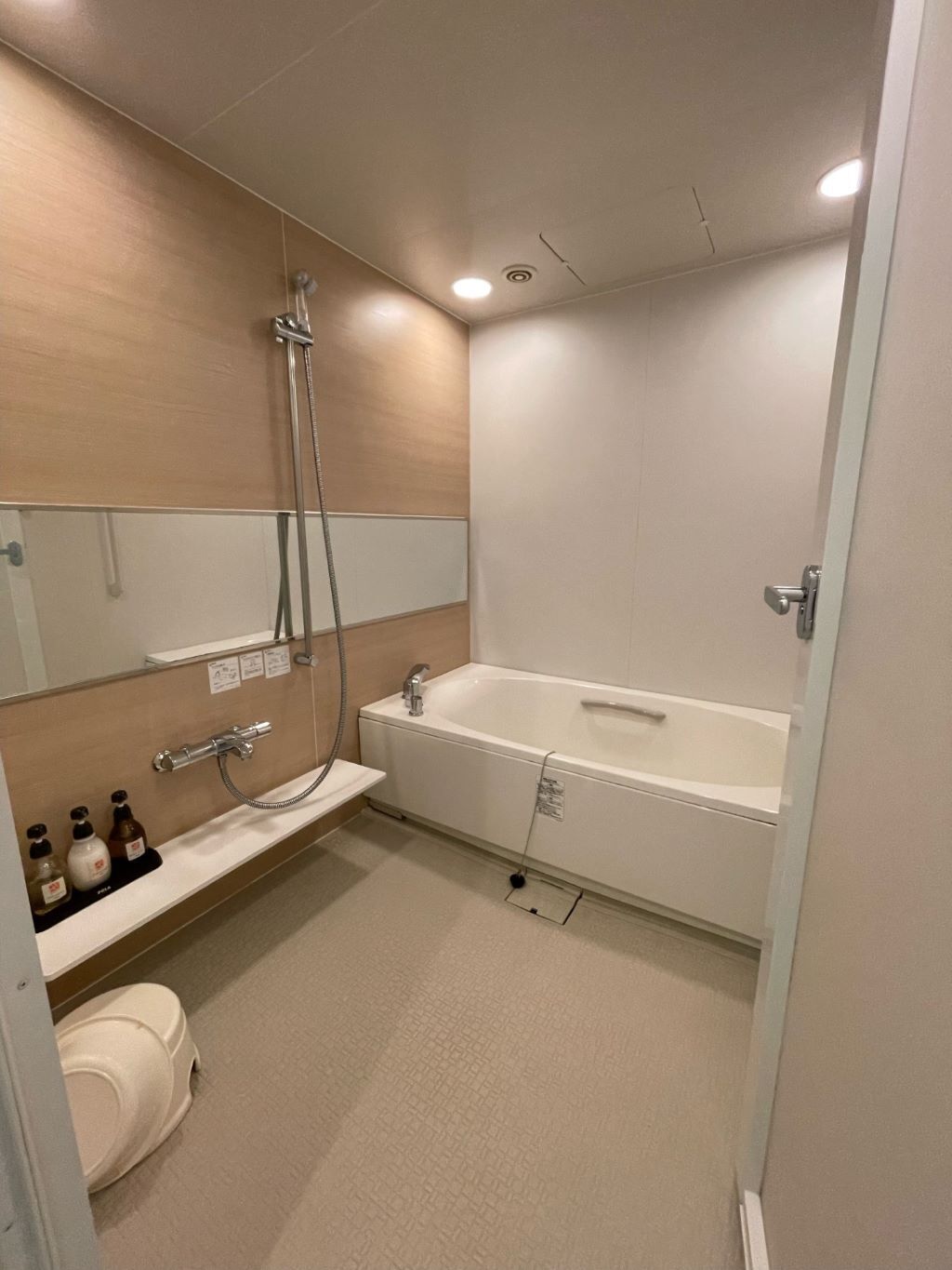 A modern bathroom with a bathtub, shower, and toilet.