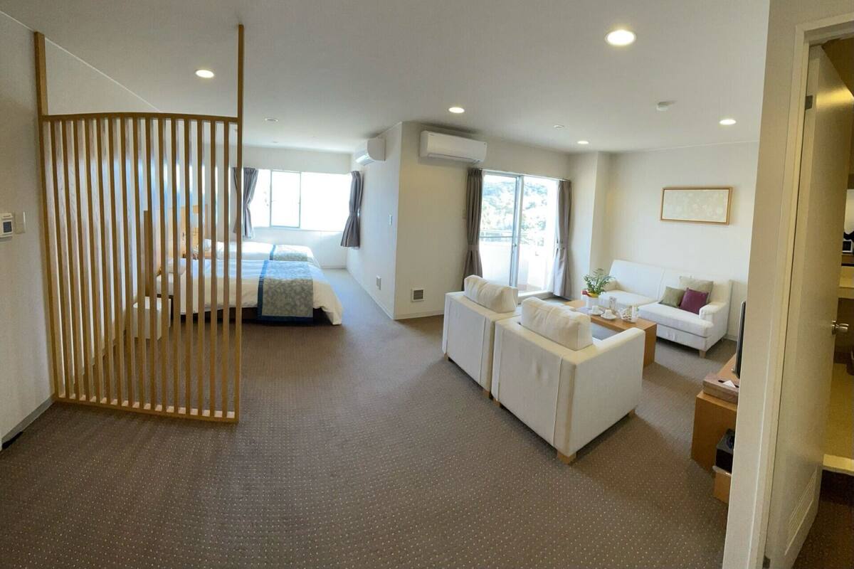 Een hotelkamer met een bed, een bank, een bureau en een eettafel.