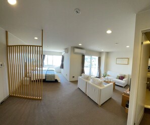 A hotel room with a bed, a sofa, a desk, and a dining table. - Wisterian Life Club Toba (Toba)