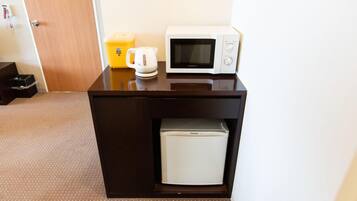 A compact kitchenette with a microwave, a coffee maker, and a mini-fridge.