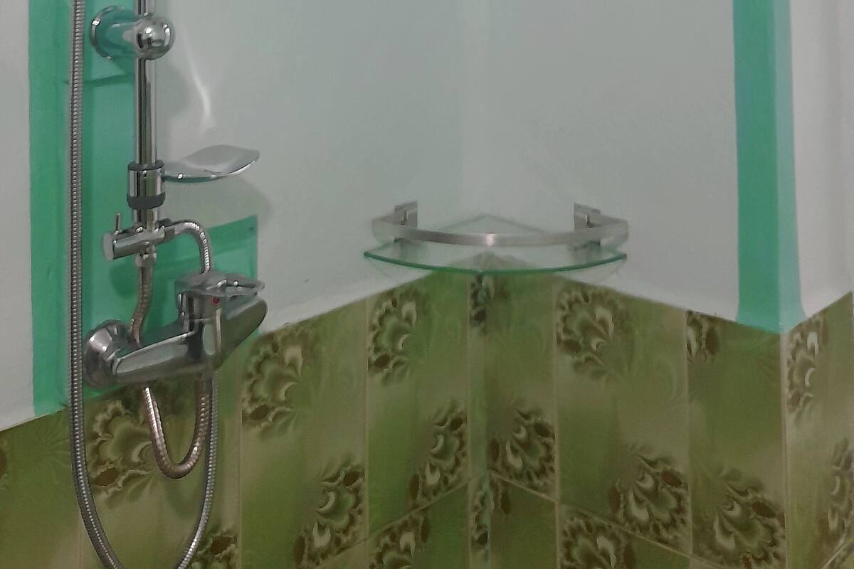 A shower with a handheld showerhead and a fixed overhead showerhead.
