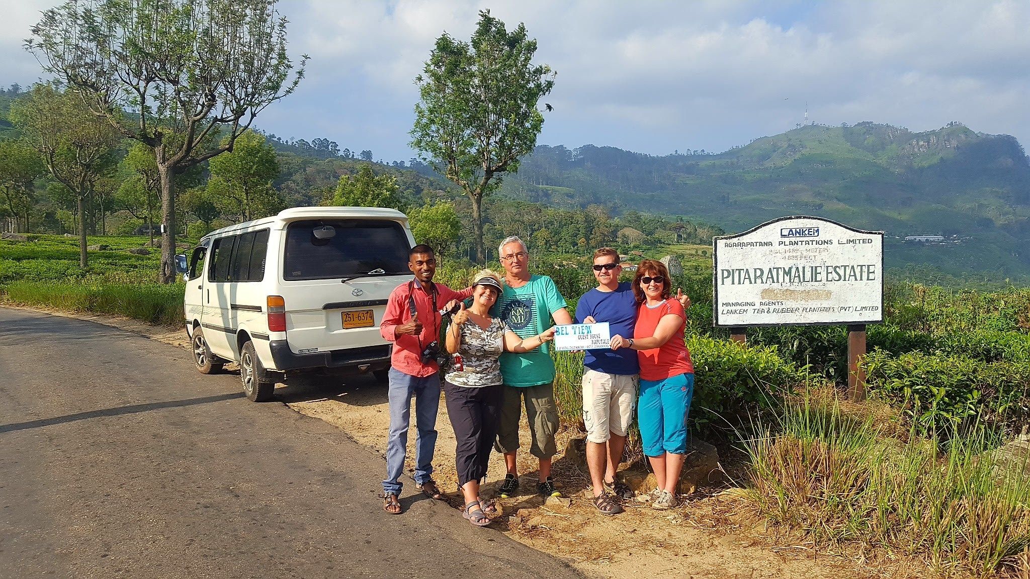 Un grupo de personas junto a una furgoneta y un cartel que indica una propiedad agrícola.
