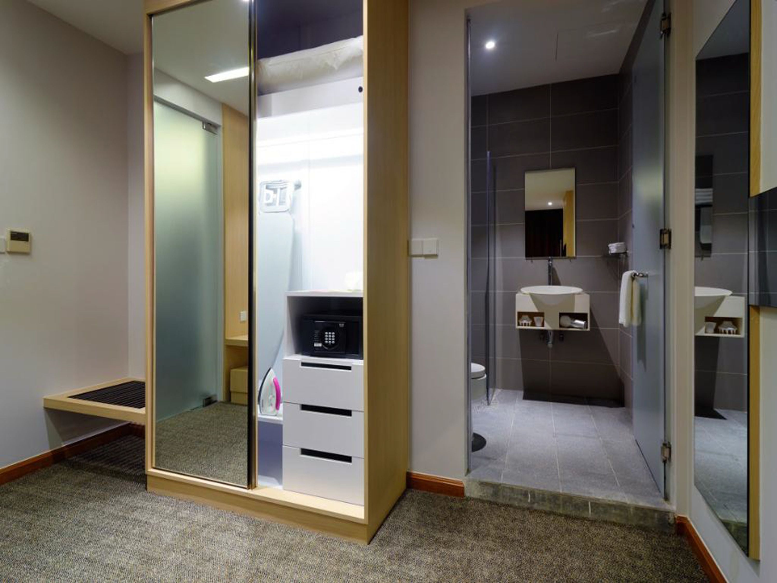 A modern bathroom with a glass shower enclosure, a white sink, and a mirror above the sink.