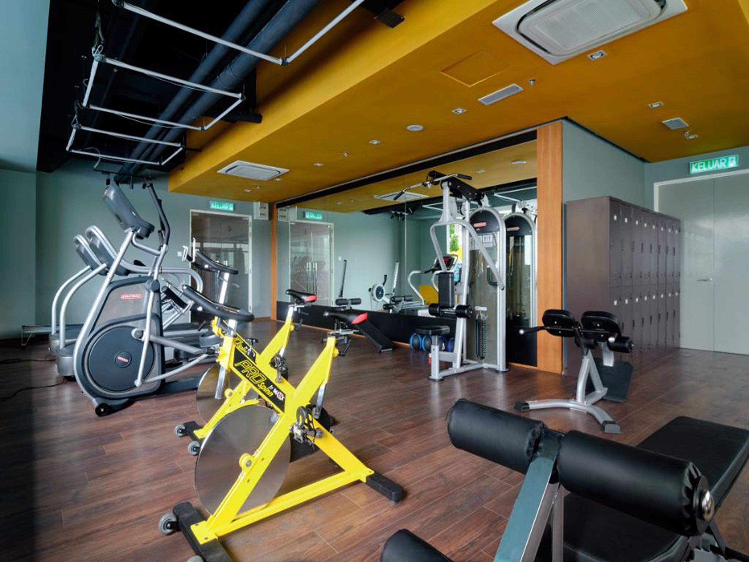 A gym with cardio machines, weight training equipment, and lockers.