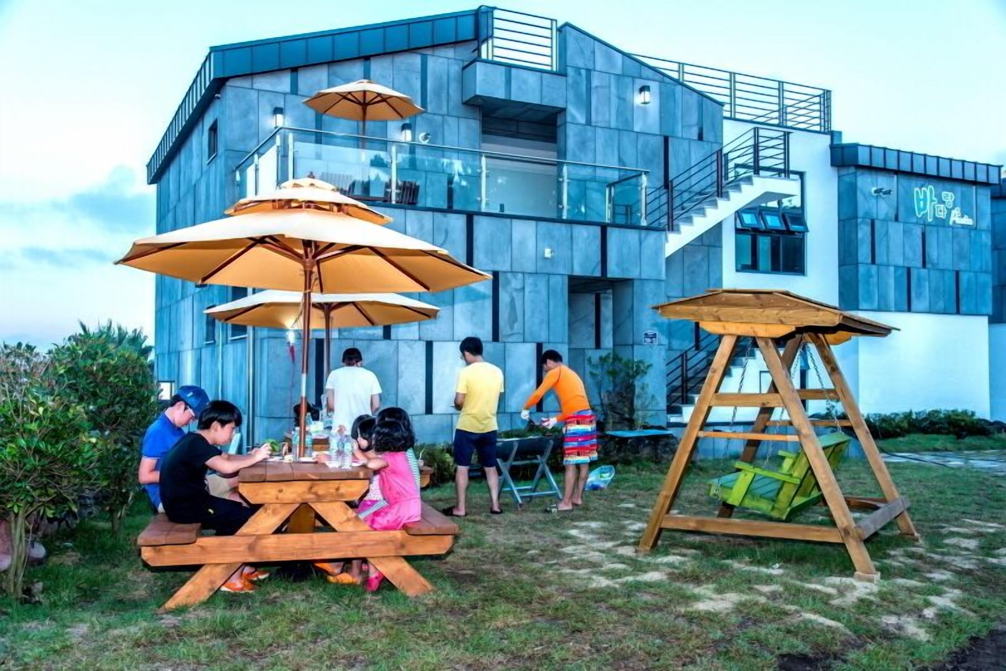 Um edifício moderno com escada e mesa de piquenique com guarda-sóis.