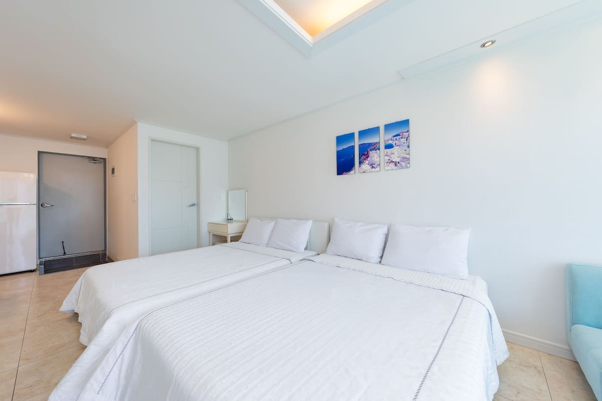 Une chambre d’hôtel avec deux lits, une salle de bain et un petit coin salon.