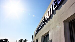 Señal de hotel con el nombre 'Pinnacle Hotel' sobre un cielo despejado.
