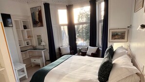 A neatly arranged bedroom with a large bed, a desk, and shelves. - Failte Bed and Breakfast (Oban)