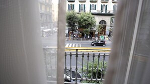 A street view through a window with a view of buildings, a crosswalk, and a car. - B&B Rettifilo (Naples)
