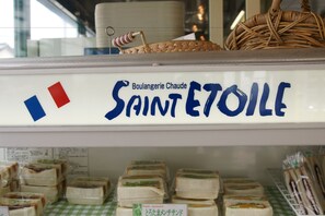 Freshly prepared sandwiches are neatly arranged on a tablecloth in Boulangerie Chaude Saint-Étienne.