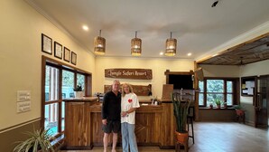 Un espace d’accueil avec un bureau en bois, des certificats encadrés accrochés au mur et une enseigne indiquant « Jungle Safari Resort ».