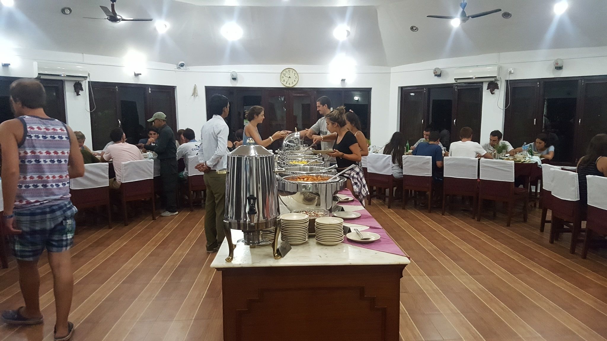 A buffet setup with multiple food stations and a clock on the wall.
