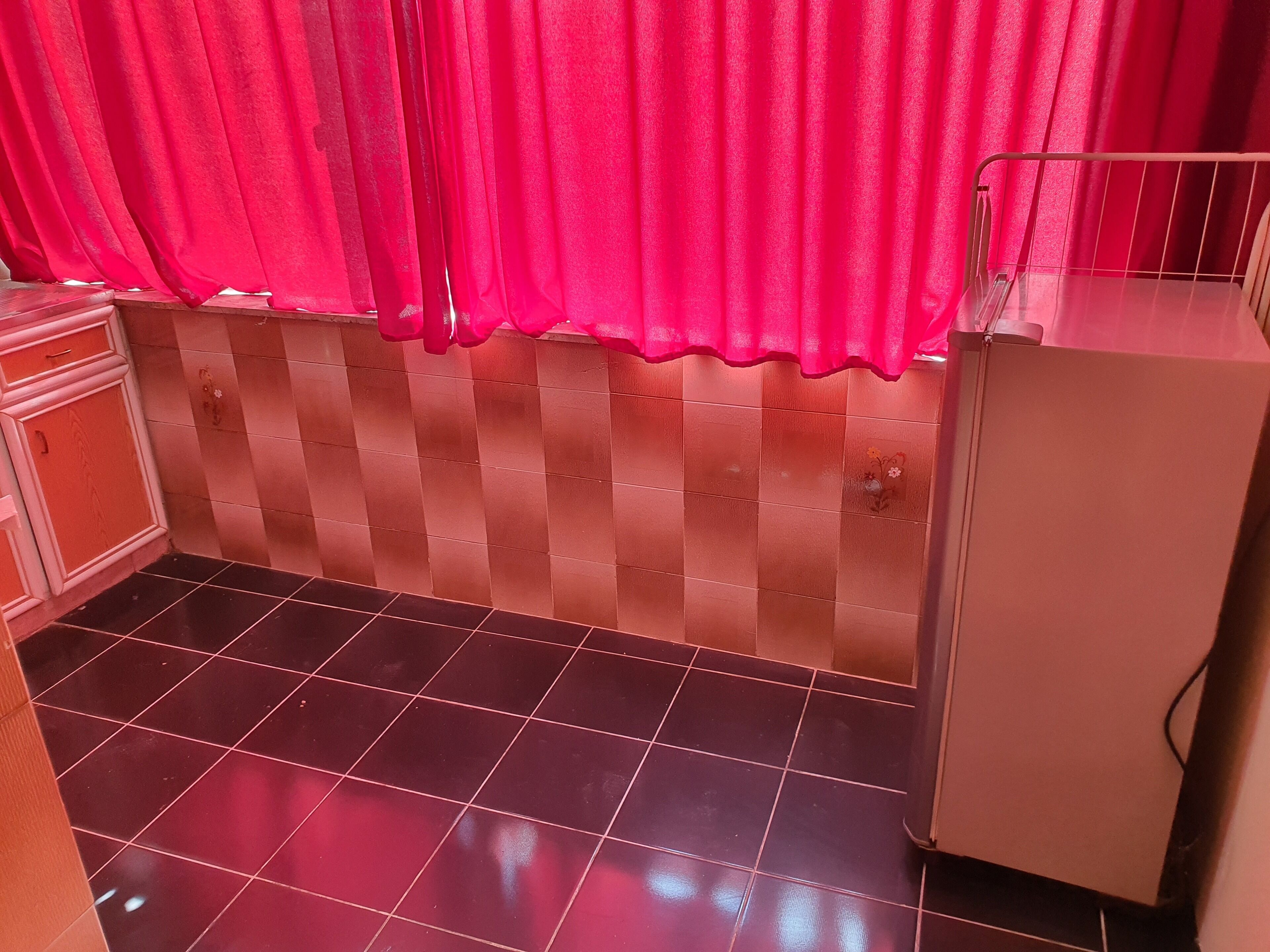 A small kitchen with a tiled backsplash, a sink, and a countertop.