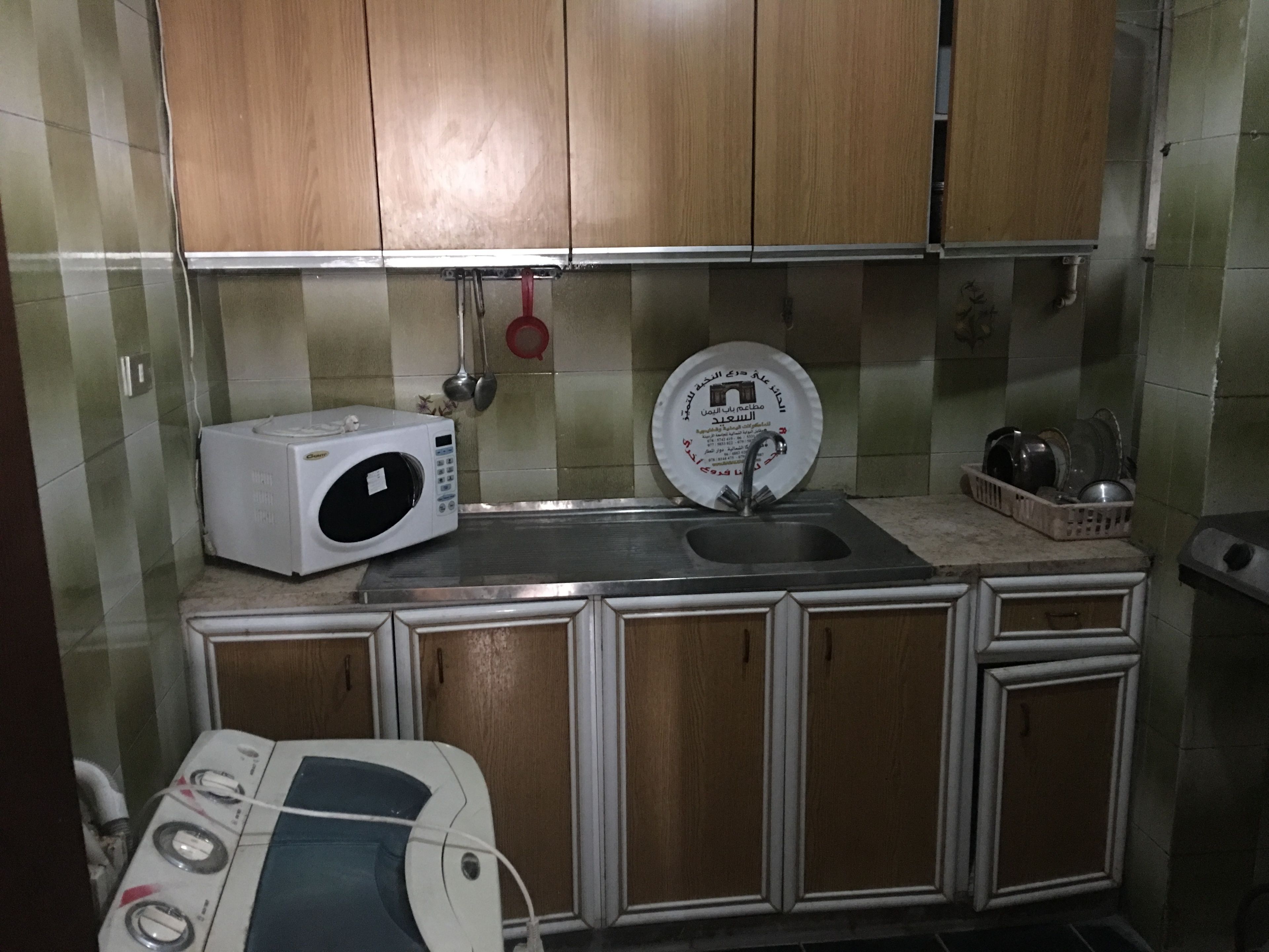 A compact kitchen with a microwave, sink, and stove.