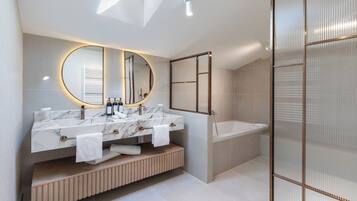 A modern bathroom with a skylight, a large mirror, a dual sink vanity, and a walk-in shower.