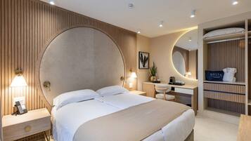 A hotel room with a large bed, bedside table, lamp, and a built-in wardrobe.