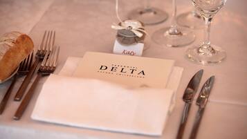 A neatly arranged table setting with a folded napkin, cutlery, a small decorative item, and a glass of water.