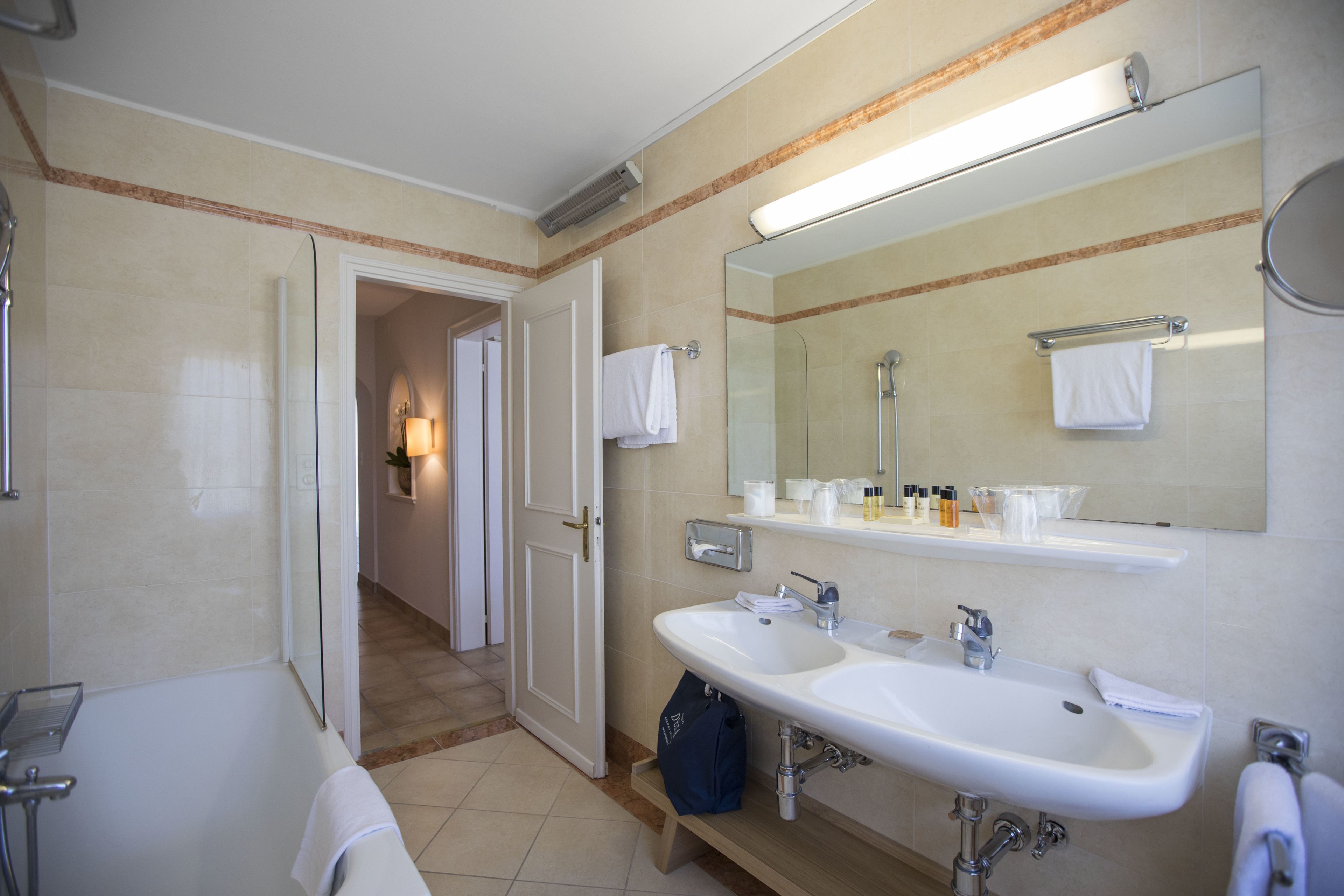 Un baño moderno con dos lavamanos, un espejo grande y una ducha.