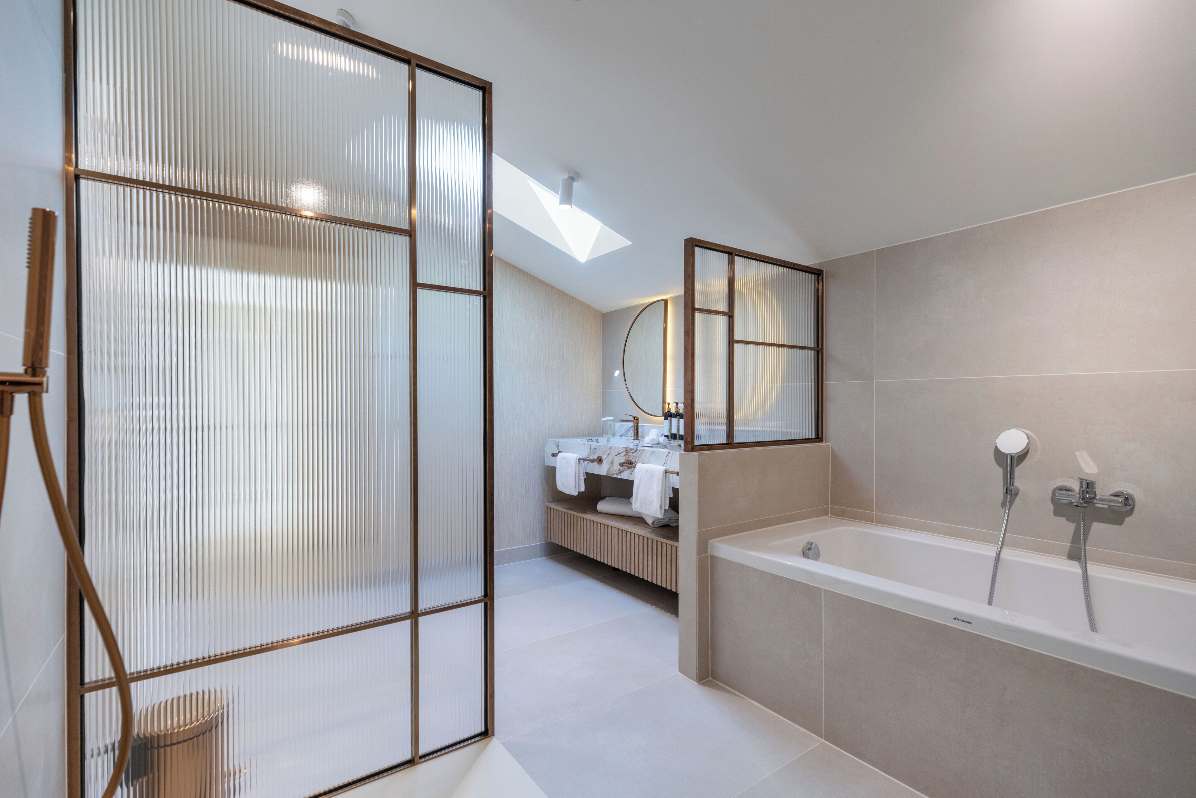 A modern bathroom with a bathtub, a shower, and a vanity with a mirror.