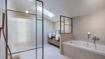 A modern bathroom with a bathtub, a shower, and a vanity with a mirror.