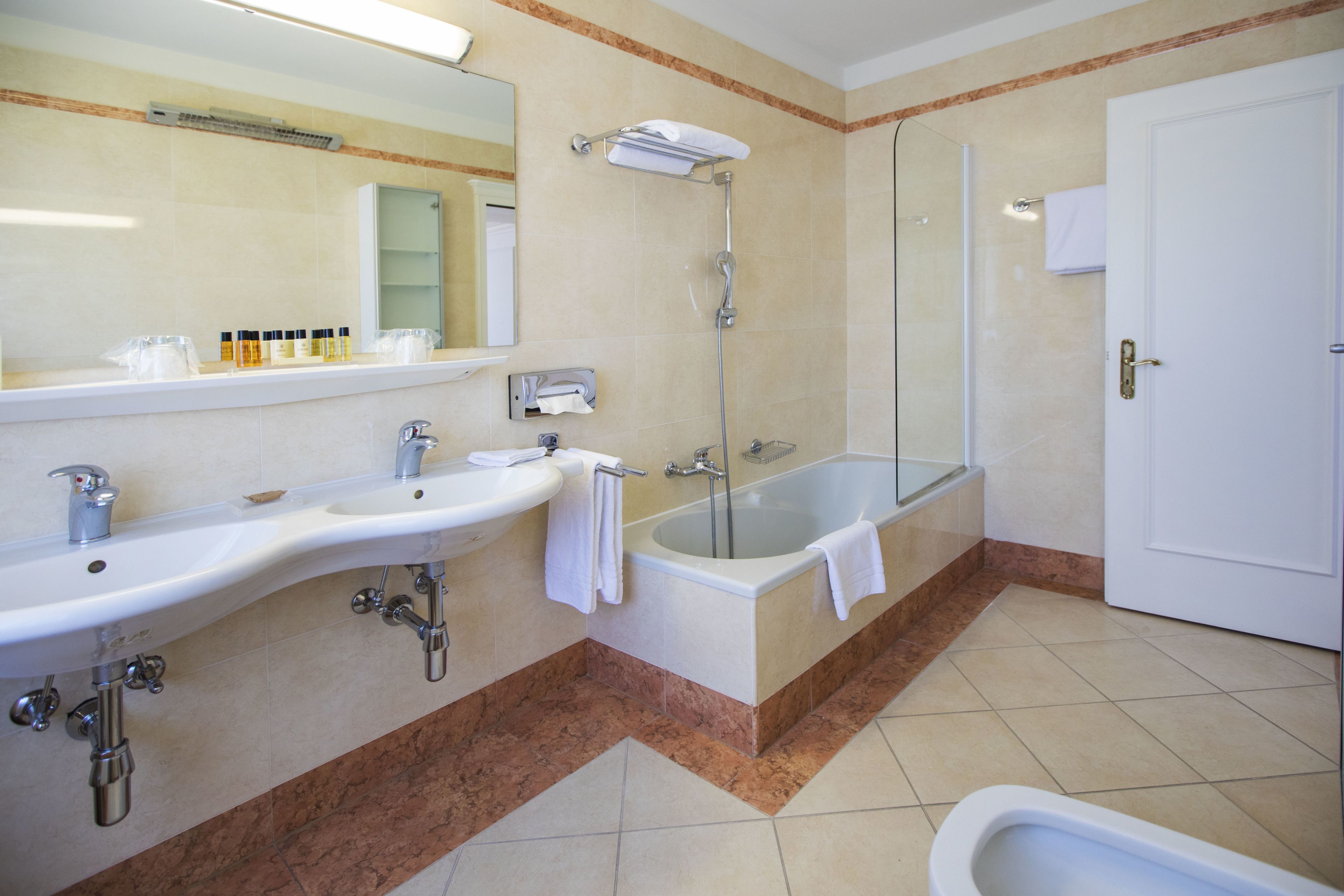 Ein modernes Badezimmer mit zwei Waschbecken, einer Badewanne und einer Dusche.
