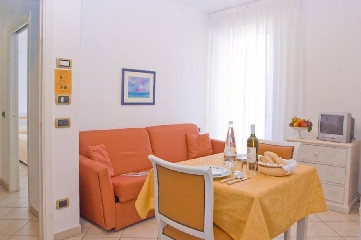 Un espacio habitable funcional con sofá, mesa de comedor y televisor.