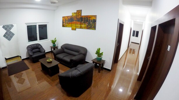 A living room with a sofa, two armchairs, a coffee table, and a painting on the wall. - Colombo Residency (Colombo)
