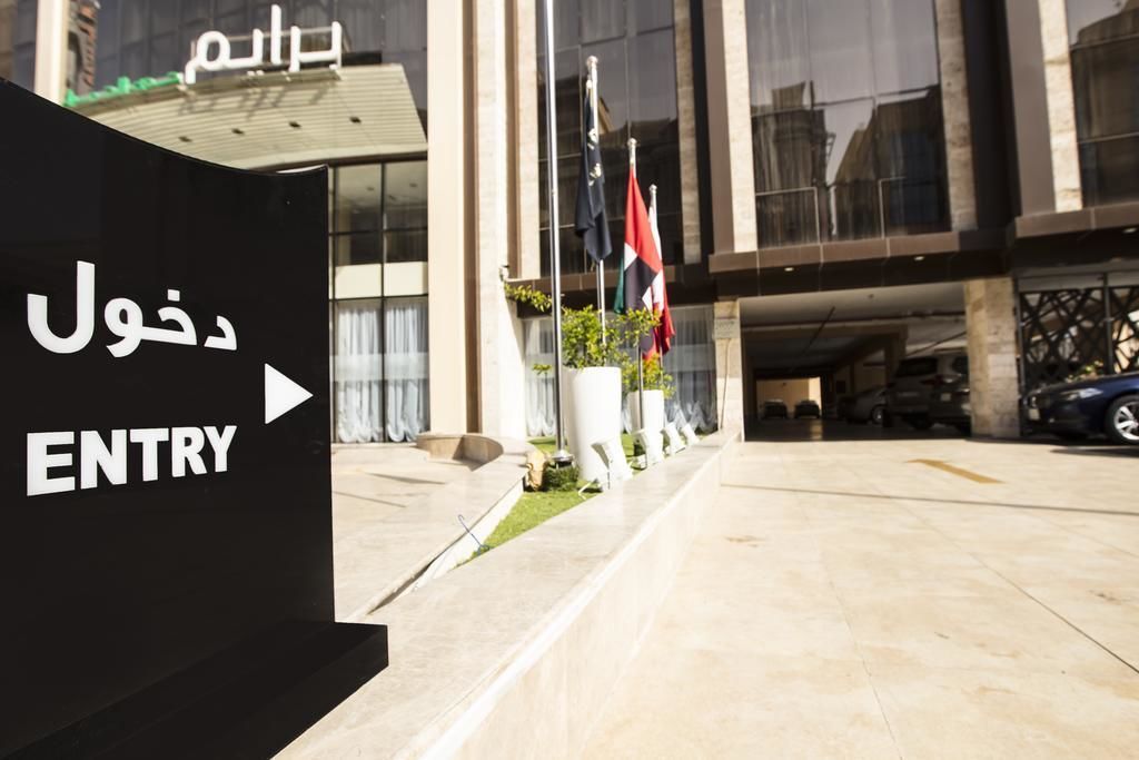 A building entrance with a sign indicating 'ENTRY' and Arabic text.