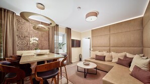 A modern living room with a sofa, dining table, and chairs. - Residence Mozart (Salzburg)