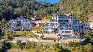 Un hotel de varios pisos con un diseño arquitectónico moderno, que cuenta con balcones y ventanas amplias.