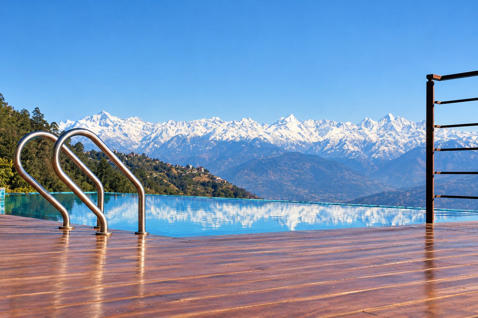 Een houten terras met een metalen hekwerk met uitzicht op een helderblauw meer en besneeuwde bergen op de achtergrond.