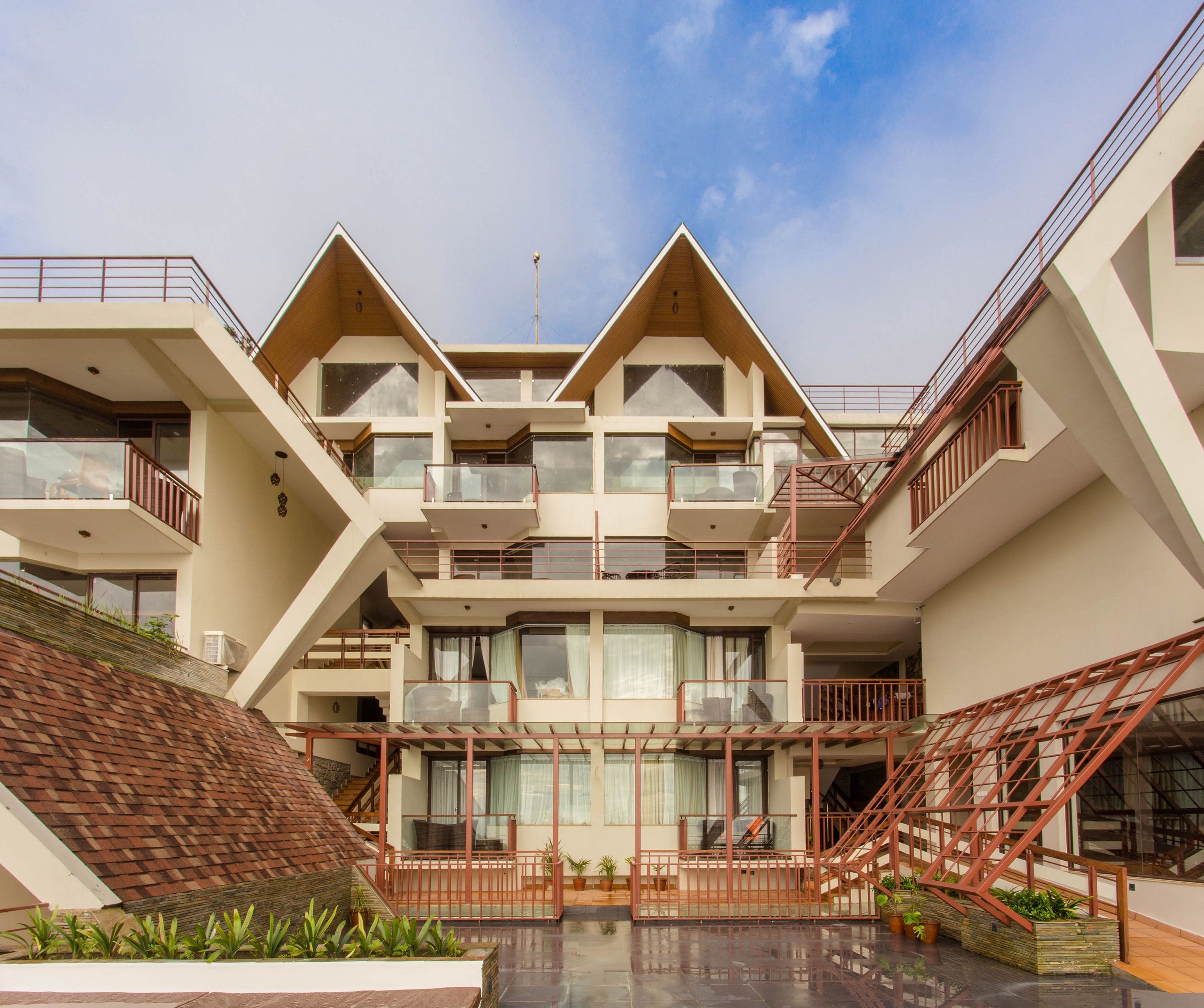 A multi-story building with balconies, a central courtyard, and a staircase.