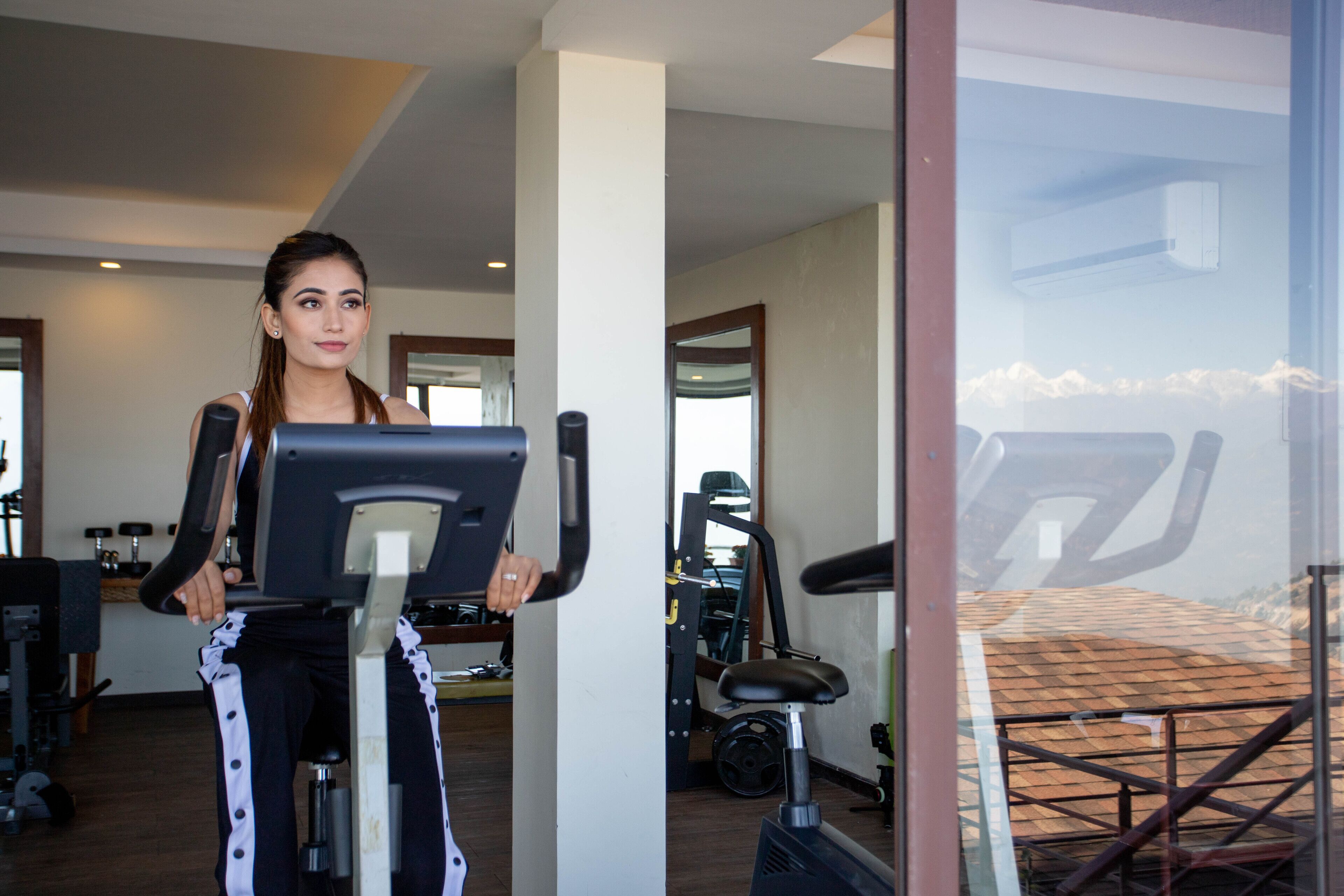 Uma academia com equipamentos de exercícios, incluindo uma bicicleta ergométrica e uma esteira.