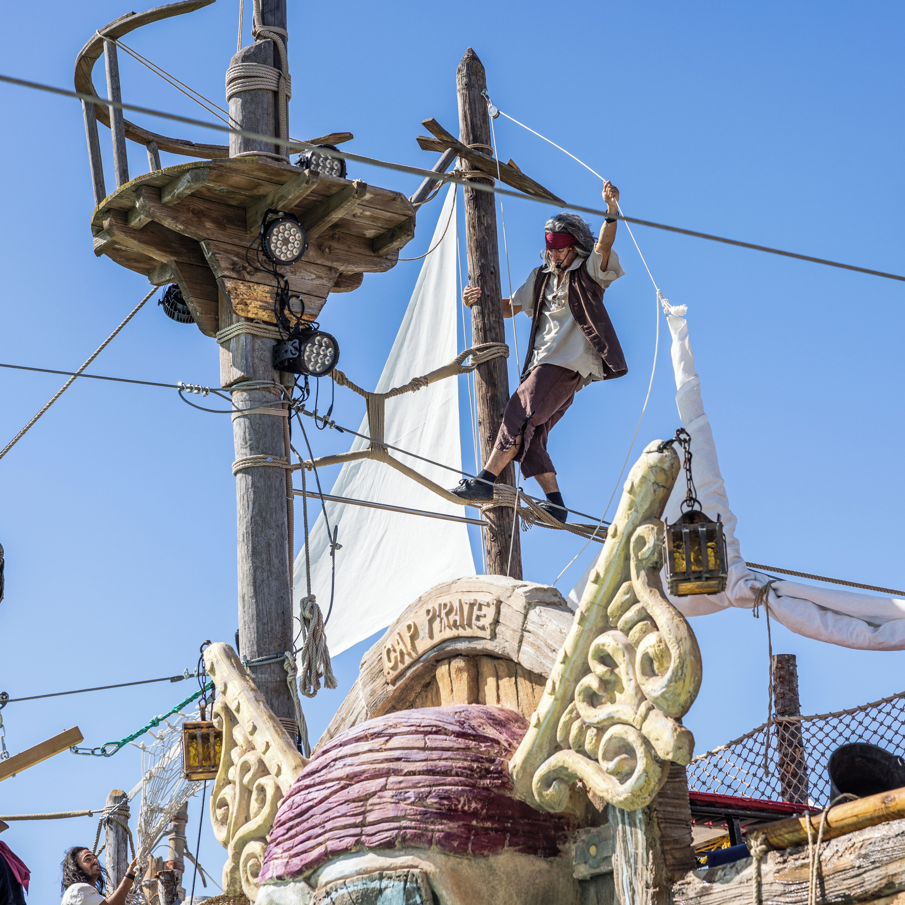 Die Takelage eines Piratenschiffs und eine Person, die den Mast hinaufklettert.