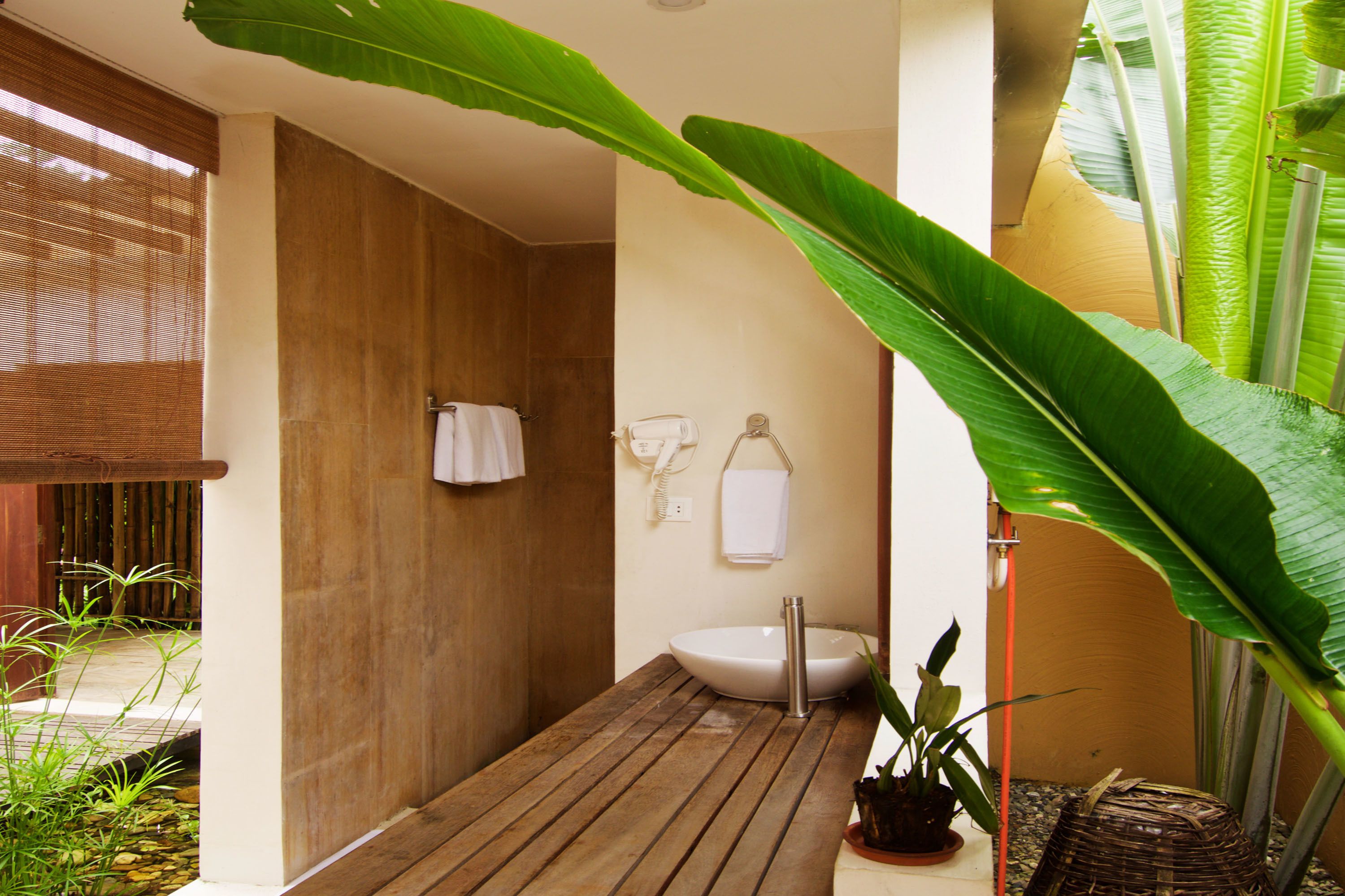 A bathroom with a wooden floor, a white sink, and a towel hanging on the wall.