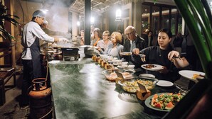 A buffet setup with a variety of dishes and a chef serving food. - Kasara Resort - Chitwan National Park (Bharatpur)