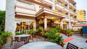 A hotel with a patio area featuring outdoor seating and potted plants. - Hotel Iceland (Pokhara)
