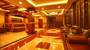 A hotel reception area with a marble floor, a reception desk, and a staircase leading to the upper floors. - Hotel Iceland (Pokhara)