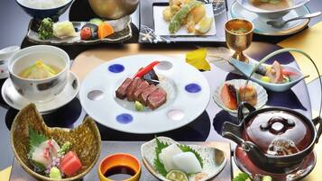A variety of Japanese dishes arranged on a table, including sushi, sashimi, and bowls of soup.