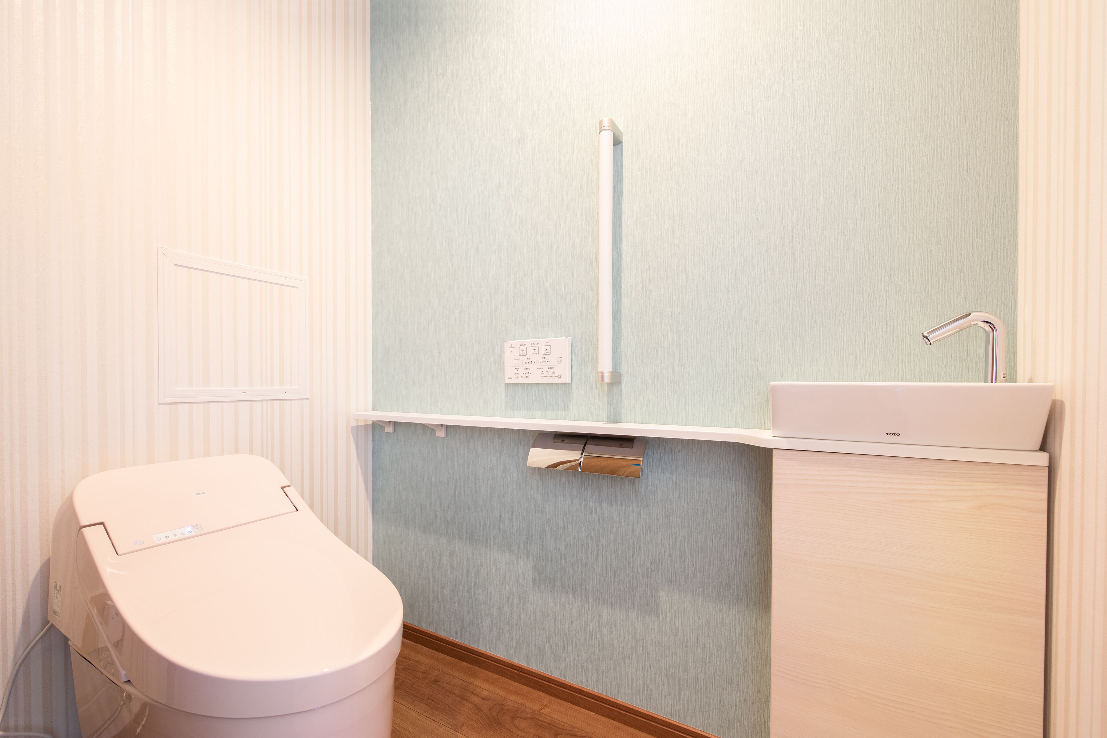 A bathroom with a toilet, a sink, and a towel rack.
