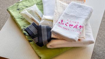 A table with various towels and a green cloth.