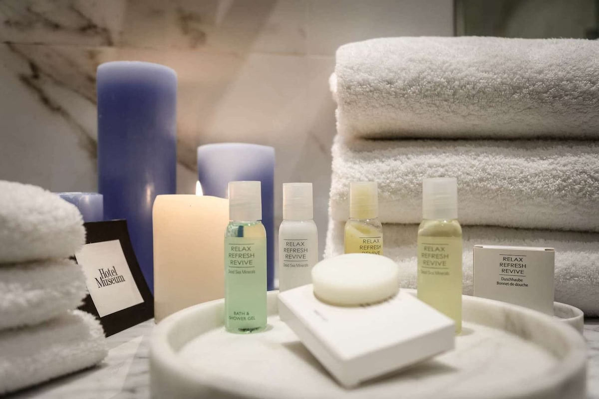 A bathroom setting with towels, candles, and bath products.