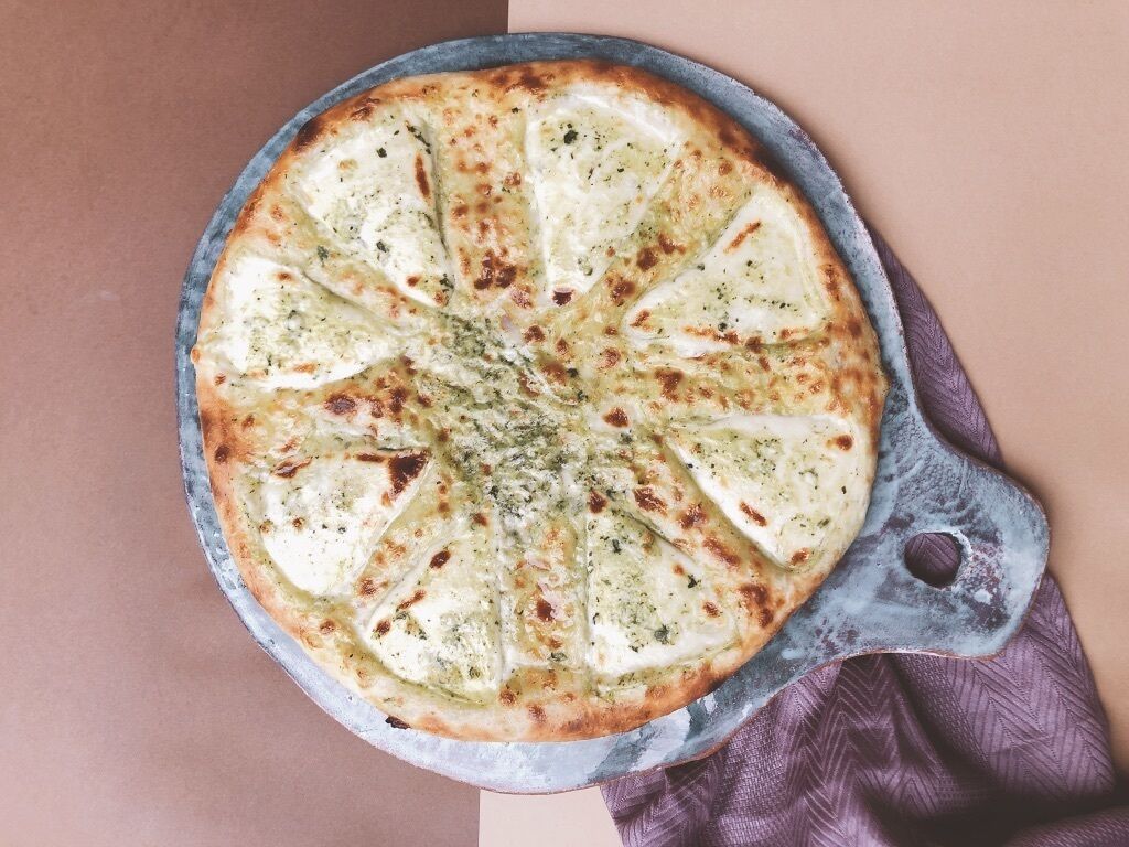 Una pizza en una sartén redonda de hierro fundido.