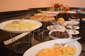 A buffet with various dishes including pastries, fruits, and nuts. - Tilal Almadina Hotel & Suites (Amman)