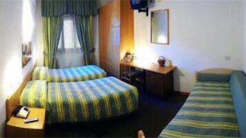 Een kleine, praktische kamer met twee bedden, een bureau en een stoel.