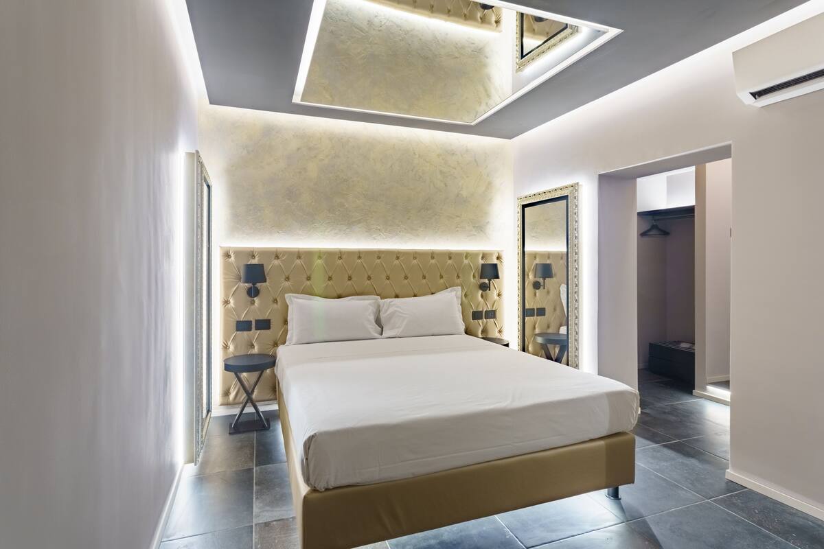 Une chambre moderne avec un grand lit, une fenêtre de toit et un dressing.