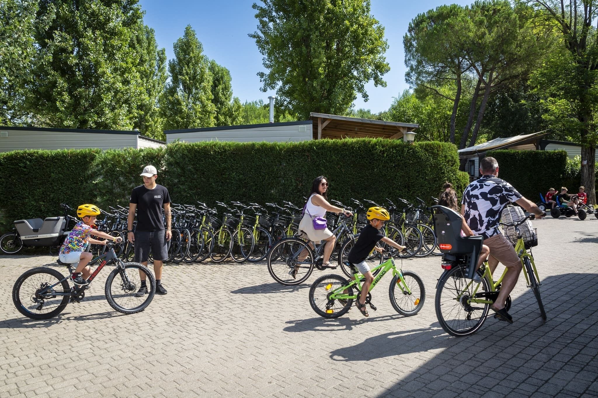 Un’area esterna pavimentata con biciclette parcheggiate lungo il bordo.