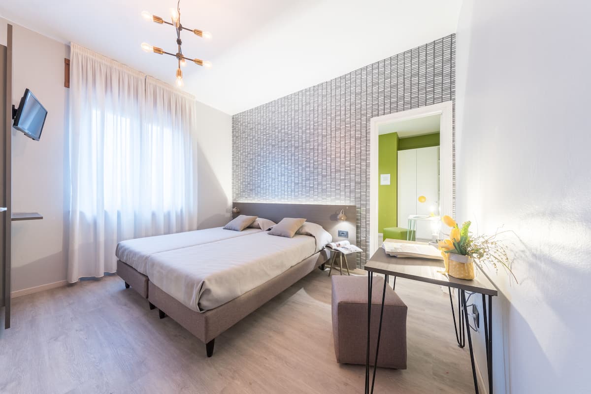 Une chambre à coucher moderne avec un grand lit, une table de chevet et un miroir.